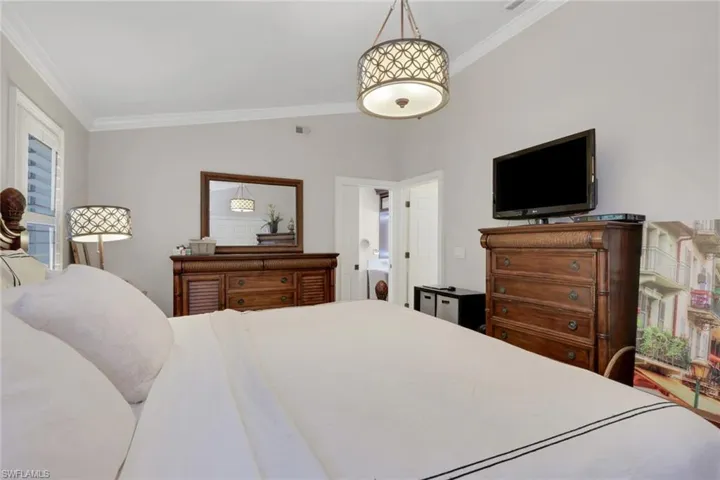 Bedroom with ornamental molding and vaulted ceiling