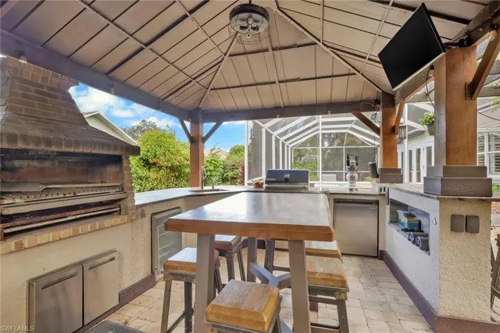 View of patio / terrace with area for grilling and a lanai