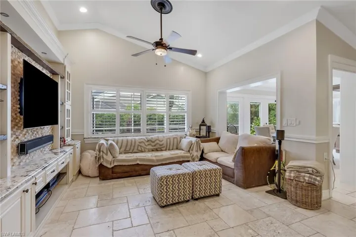 Living area featuring ornamental molding, plenty of natural light, stone tile flooring, ceiling fan, and recessed lighting