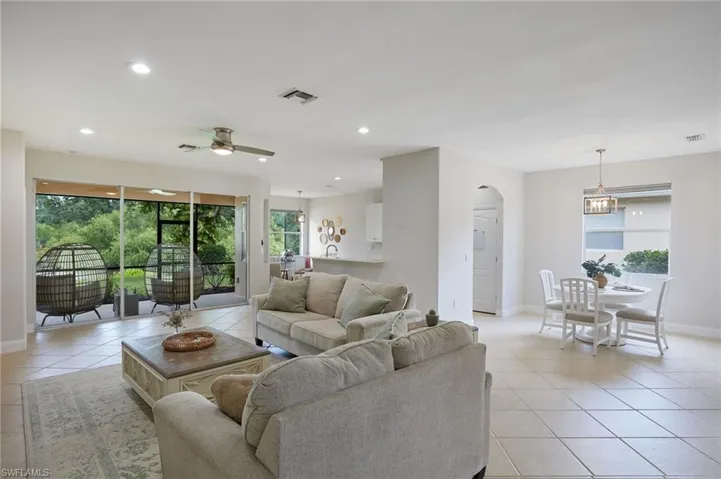 Spacious living area featuring neutral tile flooring and recessed lighting