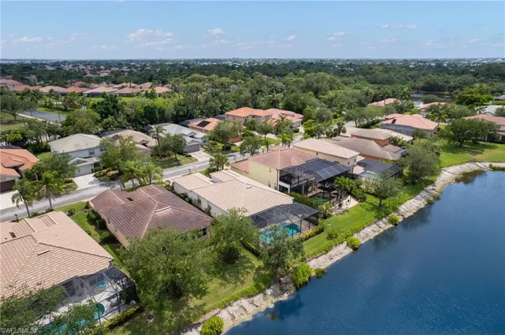 Residential properties with tiled roofs, screened pool enclosures, and direct water frontage