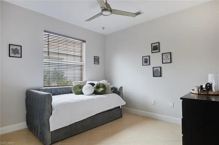 Light-toned ceramic tile flooring complements the neutral wall color