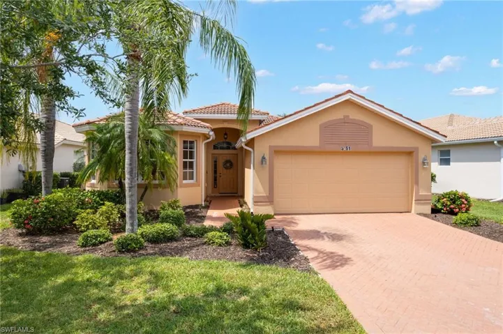 Mediterranean-style home featuring a terracotta tile roof, stucco exterior, and an attached two-car garage