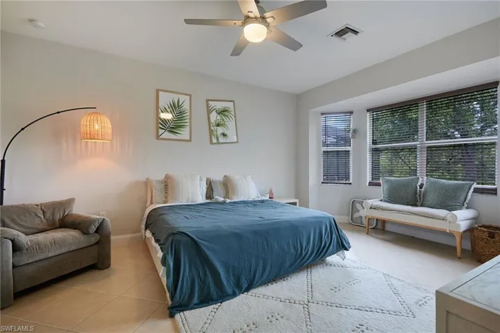 Recessed lighting, ceiling fan with integrated light fixture, large windows with horizontal blinds, neutral wall paint, and tile flooring