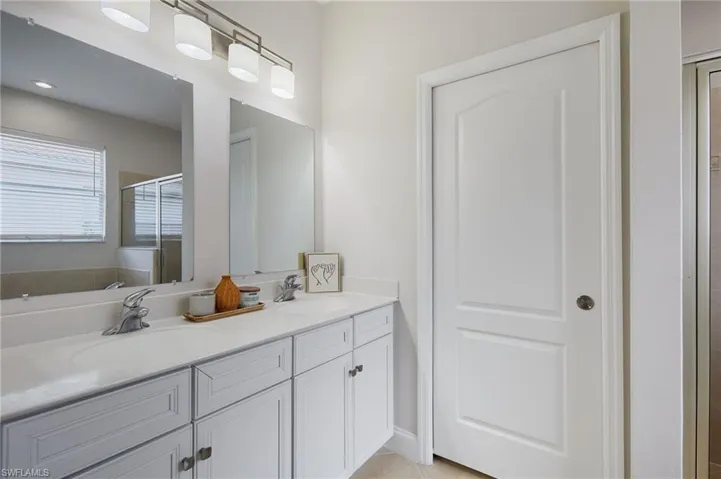 Dual vanity with undermount sinks, light-toned countertop, and light-colored cabinetry