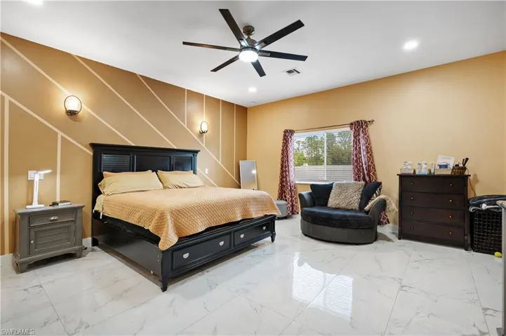 Bedroom with light marble finish flooring, ceiling fan, baseboards, and recessed lighting