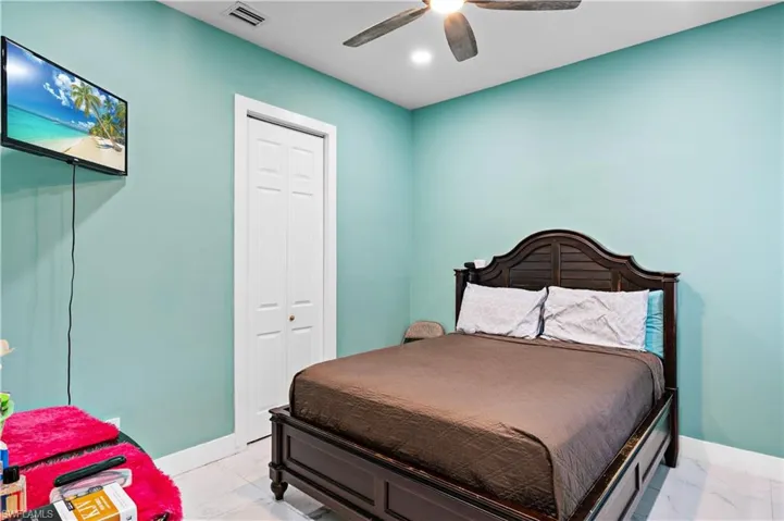 Bedroom with light marble finish floors, baseboards, ceiling fan, and recessed lighting