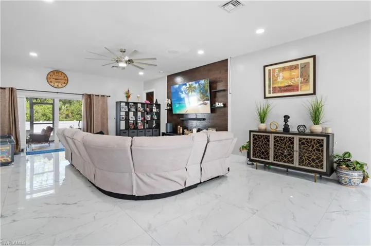 Living area with marble tiled flooring, recessed lighting, and a ceiling fan