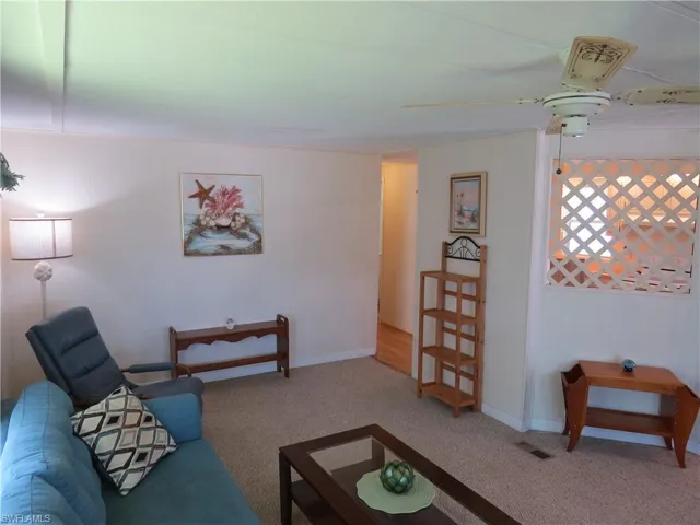 Living room featuring carpet floors and ceiling fan