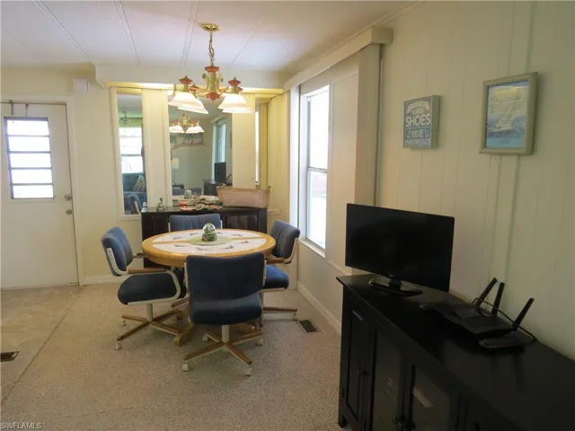 Dining space featuring a chandelier and light carpet