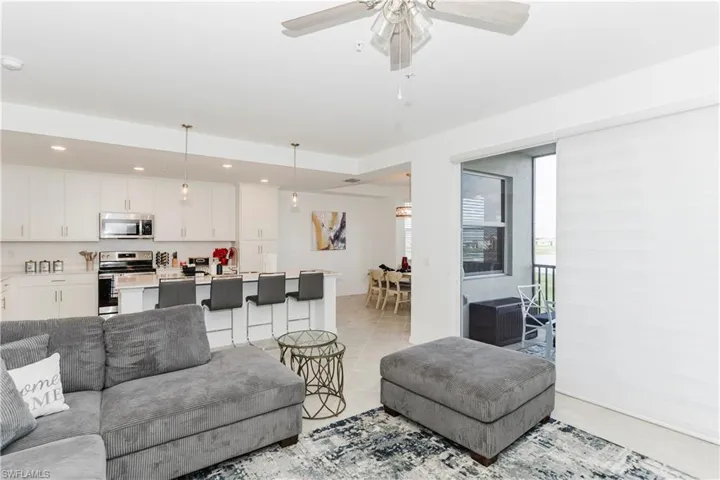 Living room with light tile patterned floors, a ceiling fan, and recessed lighting
