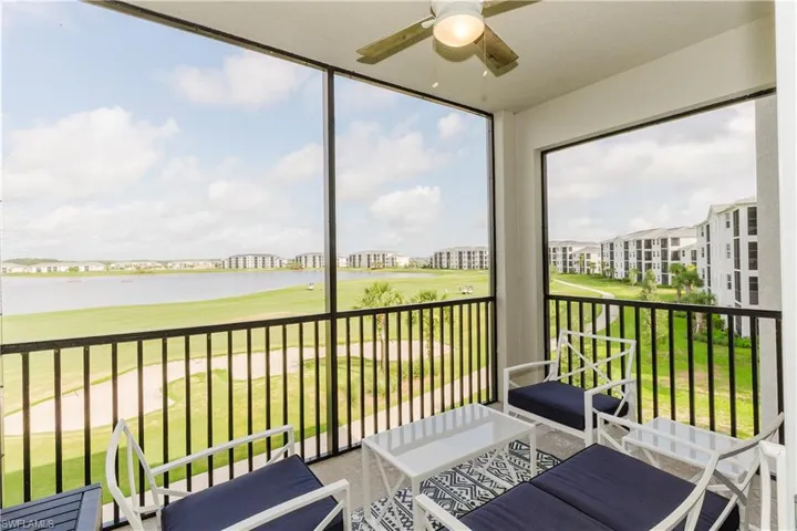 Sunroom featuring ceiling fan, a water view, and golf course view