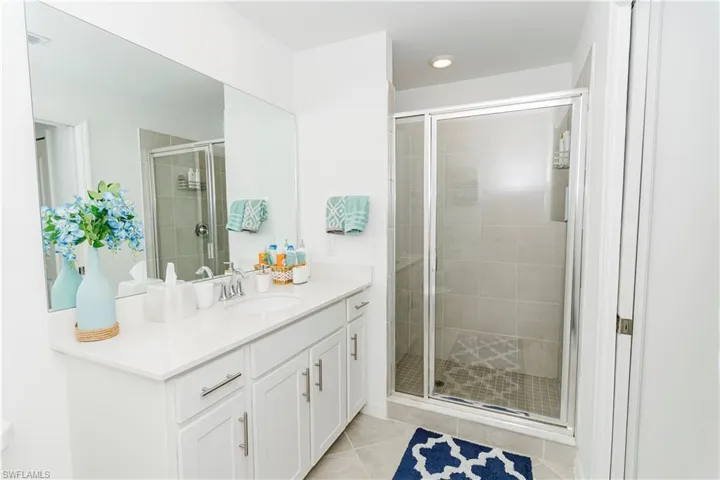 Full bath featuring vanity, a stall shower, and tile patterned floors