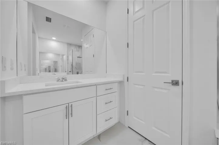Full bathroom with vanity and a marble finish shower