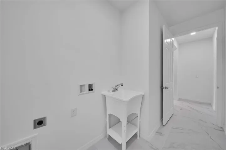Laundry room featuring light marble finish floors, hookup for a washing machine, and electric dryer hookup