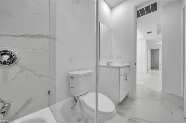Bathroom with light marble finish floors and vanity