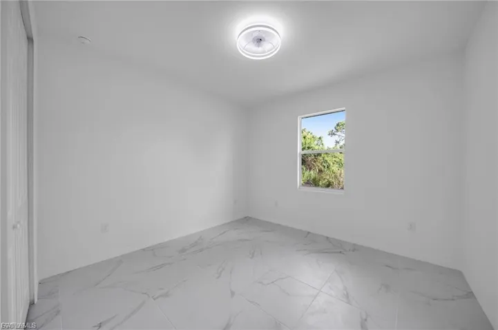 Spare room with light marble finish floors