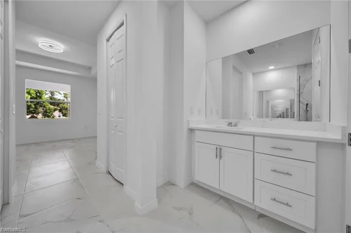 Full bath featuring light marble finish flooring and vanity
