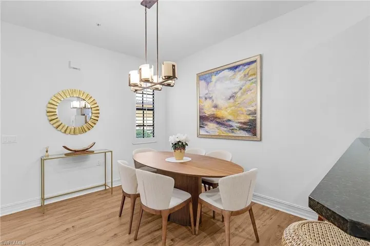 Dining area featuring light wood-style flooring, a chandelier, and baseboards