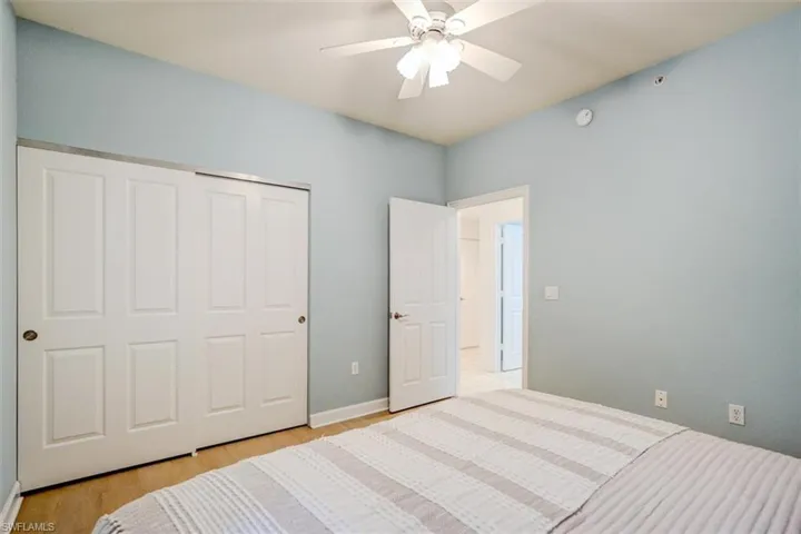 Bedroom with ceiling fan, a closet, and light hardwood / wood-style flooring