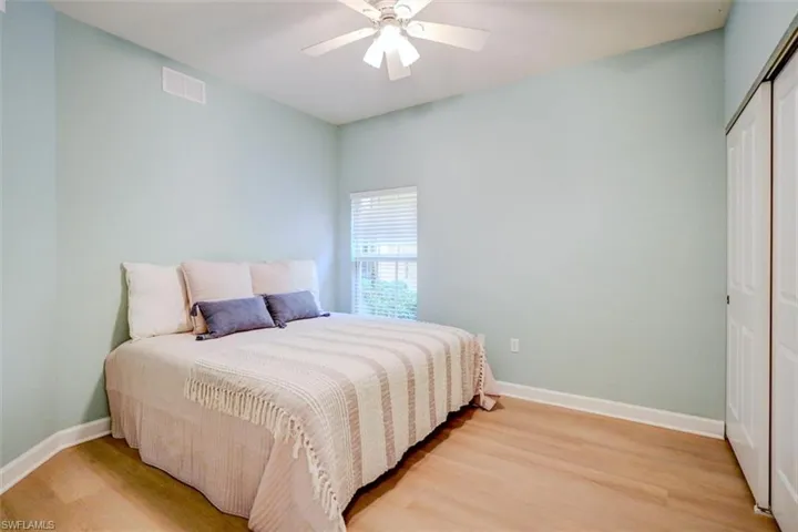 Bedroom with hardwood / wood-style floors, ceiling fan, and a closet