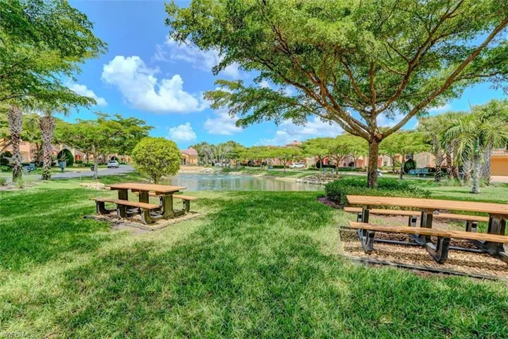 View of property's community featuring a lawn and a water view