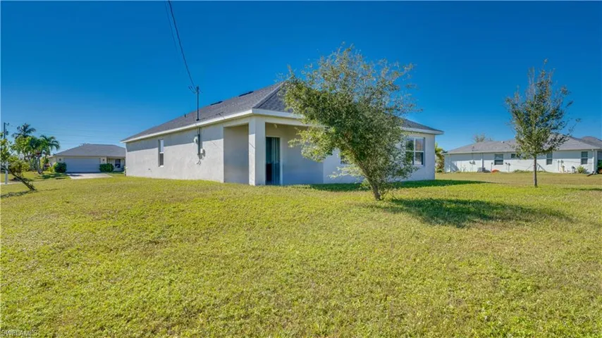 Rear view of house with a yard and stucco siding