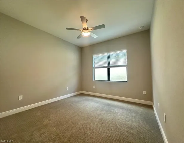 Carpeted empty room with ceiling fan