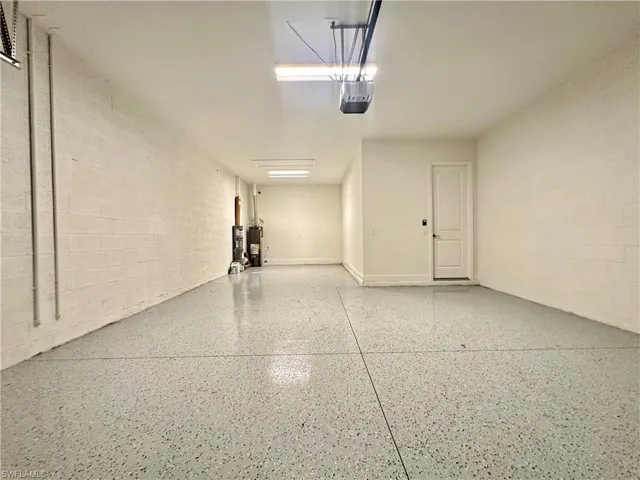 Garage featuring a garage door opener and water heater