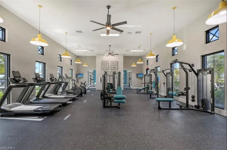 Gym featuring a towering ceiling and ceiling fan