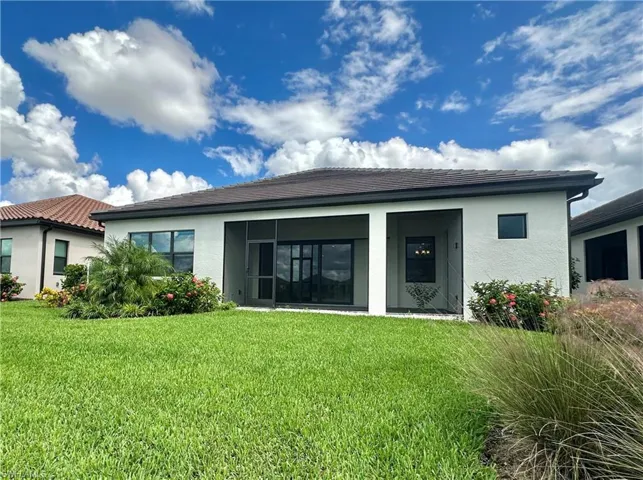 Back of property with a lawn