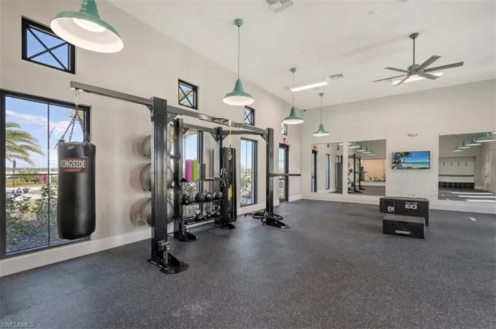 Exercise room with a high ceiling and ceiling fan