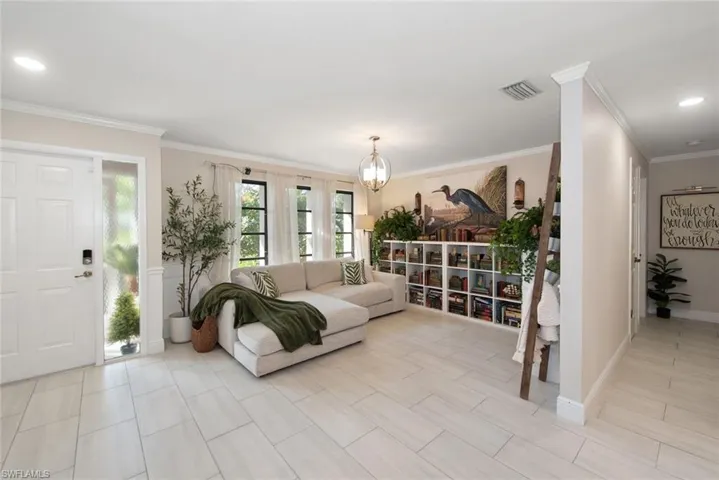 Living room with ornamental molding, a chandelier, recessed lighting, and wood finish floors