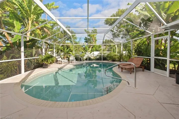 Swimming pool with a patio, a sunroom, and glass enclosure