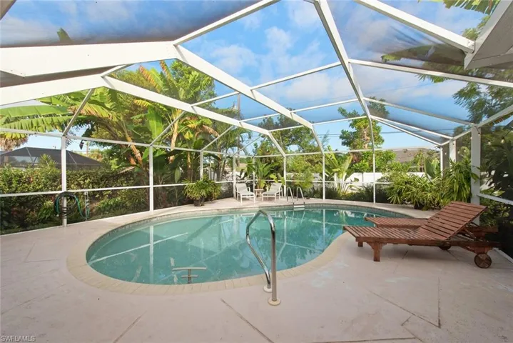 Swimming pool featuring a sunroom, a lanai, and a patio