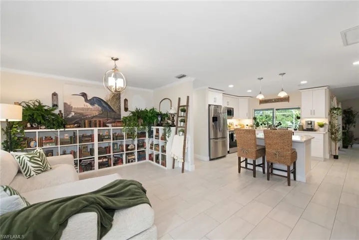 Living area featuring ornamental molding, recessed lighting, and a chandelier