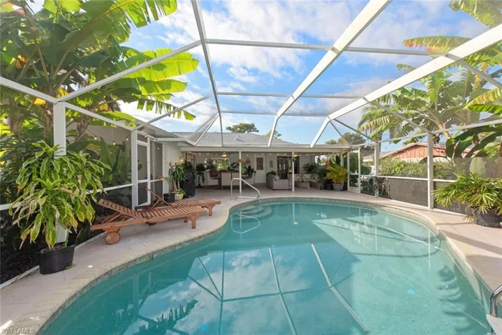 Outdoor pool featuring a sunroom, an outdoor living space, a patio, and a lanai