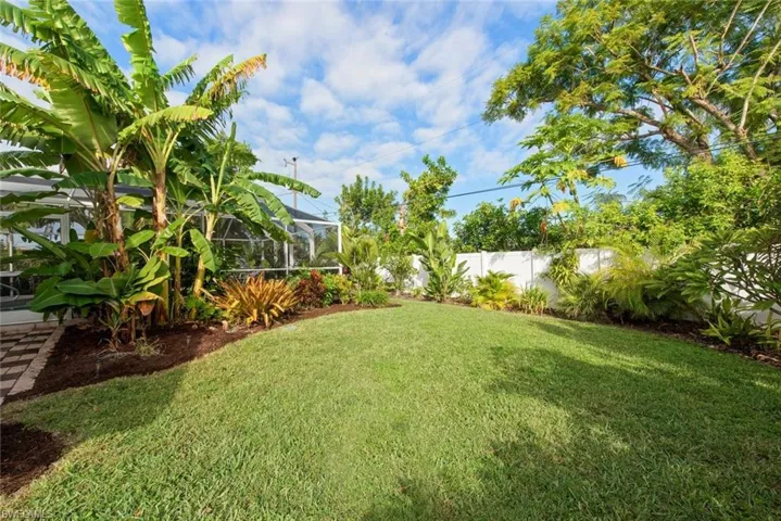 Fenced backyard featuring a lanai and a sunroom