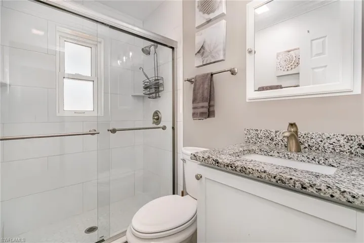 Baths have a glass-enclosed shower and white tile surround!
