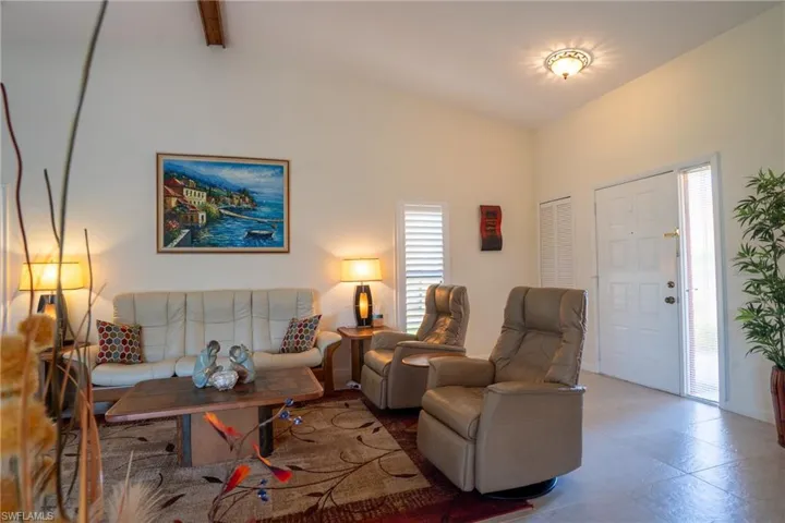 Living room with beamed ceiling and high vaulted ceiling