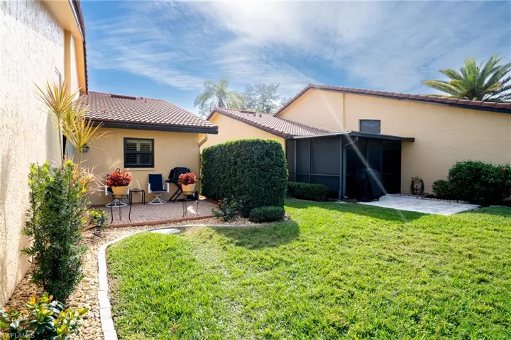 Rear view of property with a patio area and a lawn