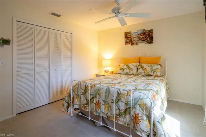 Guest Bedroom featuring tile patterned flooring, ceiling fan, and a closet