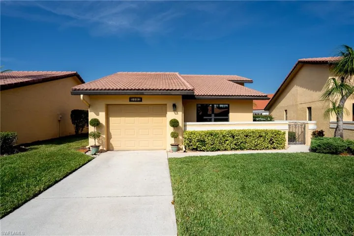 Mediterranean / spanish home with a front yard and a garage