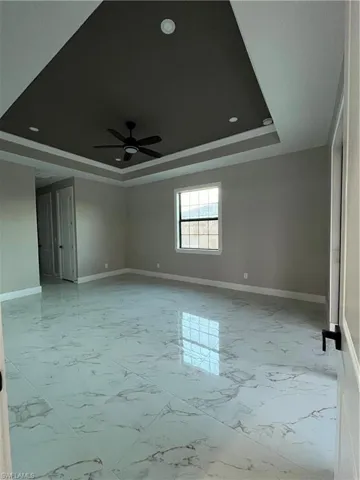 Spare room featuring ceiling fan and a raised ceiling