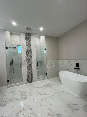 Bathroom with independent shower and bath and tile walls