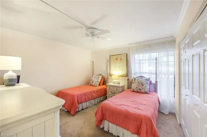 Carpeted bedroom with ceiling fan, crown molding, and a closet