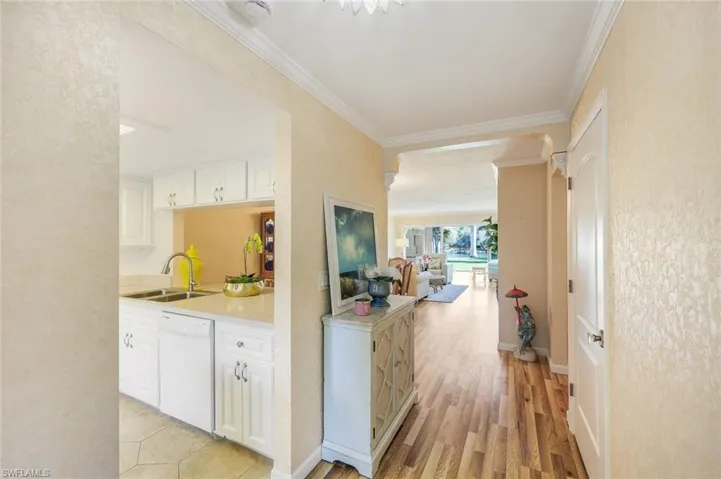 Hall featuring sink, light hardwood / wood-style flooring, and ornamental molding