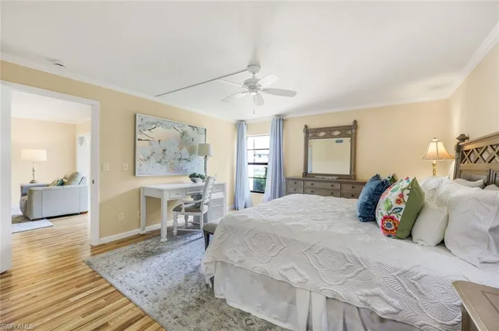 Bedroom featuring ceiling fan, crown molding, and light hardwood / wood-style flooring