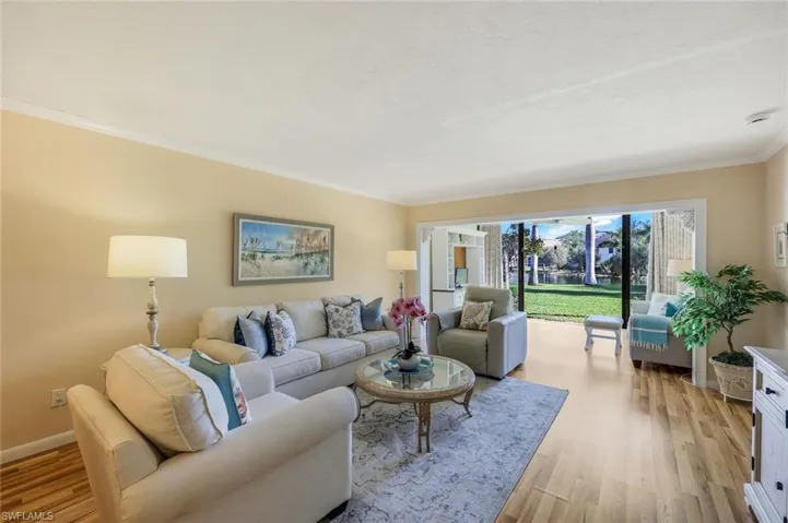 Living room with ornamental molding and light hardwood / wood-style flooring