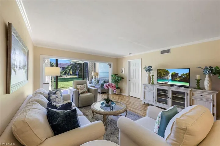 Living room with light hardwood / wood-style floors and crown molding